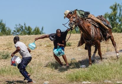 Un agente de la patrulla fronteriza a caballo agarra a un migrante haitiano que trataba de cruzar al campamento bajo el puente internacional de Del Río, el 19 de septiembre.