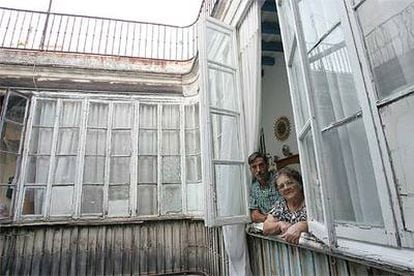 Antonia Romero, de 80 años, junto a su yerno, en la ventana de su piso del siglo XIX en la calle Cervantes de Cádiz.