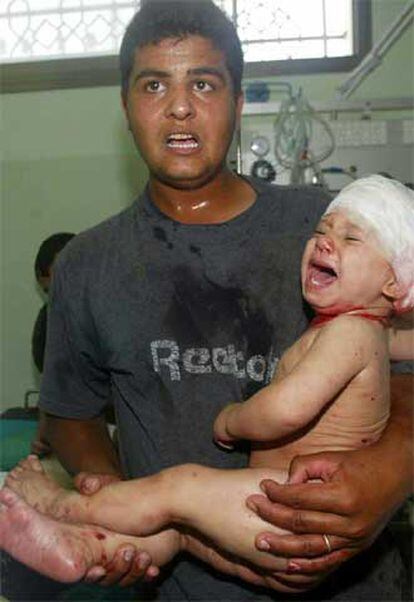 Un palestino llega al hospital con uno de los niños heridos en Gaza tras el ataque israelí.