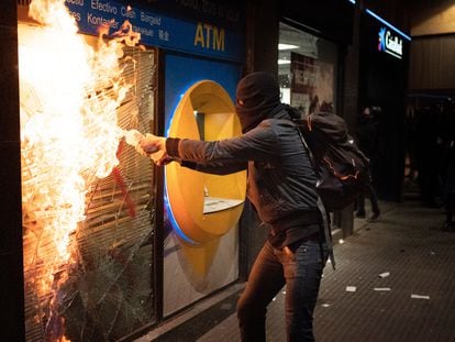 Un manifestante intenta quemar una sucursal bancaria tras las protestas en Barcelona, España, el pasado sábado.