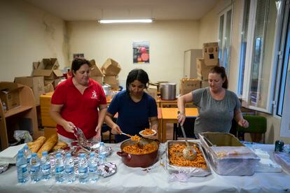 Unas voluntarias reparten comida y agua para los vecinos en el centro polivalente de la localidad.  
