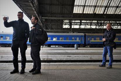 Observado por uno de sus guardaespaldas, Kamishin (izquierda) atiende en la estación de Lviv una videollamada junto a Oleksandr Pertsovskii, responsable del transporte de viajeros de la compañía.