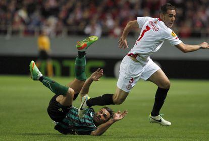 El delantero del Betis, Rubén Castro, cae ante el defensa del Sevilla, Fernando Navarro, durante el partido de ida de los octavos de final de la Liga Europa disputado esta noche en el estadio Sánchez Pizjuán