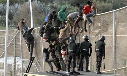 Agentes de la guardia civil junto a los inmigrantes que intentaron saltar la valla en Melilla, el 14 de octubre de 2014.