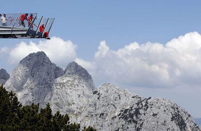 <b>ALPSPIX, ALPSPITZ (ALEMANIA). </b>Dos brazos de acero trazan una ‘X’ y se asoman al paisaje alpino en la estación de Alpspitz, en Baviera. Aunque toda la estructura mide 24 metros, solo 14 metros vuelan sobre el vacío. En la foto se ve a los operarios antes de colocar la pared de cristal al final de una de las pasarelas. Ya terminado, fue inaugurado en 2010.