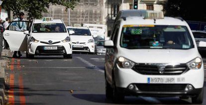 Varios taxis circulan por una calle de Madrid.