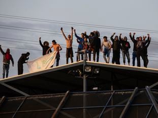 Un grupo de internos pide su liberación en el tejado del CIE de Aluche (Madrid), este martes. En vídeo, una treintena de inmigrantes protestan en el centro.