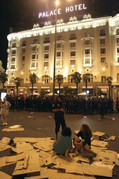 Un miembro de la policia nacional identifica a dos de las personas que han participado en la manifestación que funcionarios públicos, entre ellos policias y bomberos, han realizado por distintas zonas de la capital madrileña.
