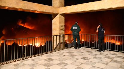 Guardias civiles contemplan el fuego de Ceuta, esta mañana.