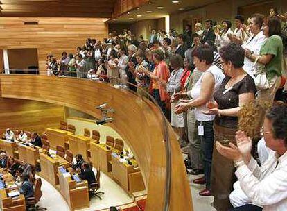 Representantes de asociaciones de mujeres aplauden la votación final, ayer en el pleno del Parlamento.