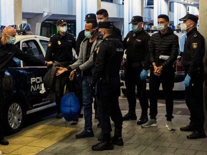 Dos jóvenes migrantes marroquíes esposados llegan al aeropuerto de Las Palmas (Gran Canaria) para ser deportados por la Policía, en diciembre de 2020.