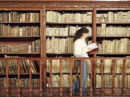 Una mujer consulta un libro en una biblioteca en Michoacán (México).