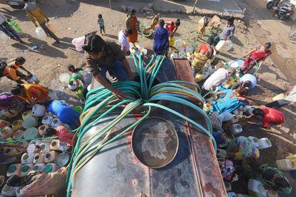 Habitantes de barrios marginados indios recogen agua potable de un buque cisterna municipal en la zona de Durga Nagar, en Bhopal, el 21 de marzo de 2018.