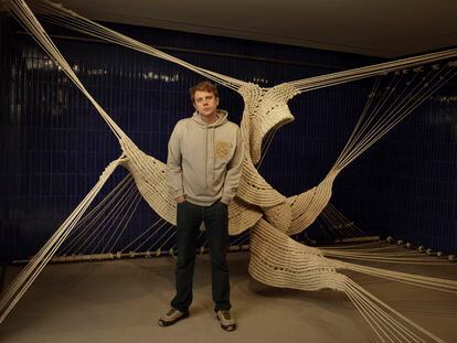 Jonathan Anderson posa delante de la instalación de macramé de la artista Aurèlia Muños en la tienda de Loewe de Barcelona.