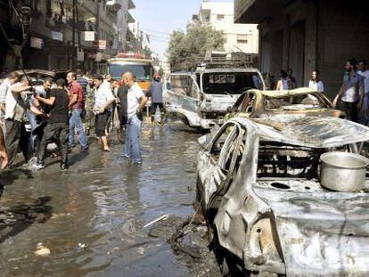 Varios vecinos inspeccionan los da&ntilde;os tras una explosi&oacute;n, en Damasco.