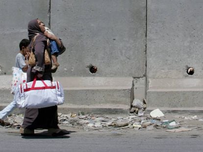 Una palestina y sus hijos caminan por la localidad de Aram.