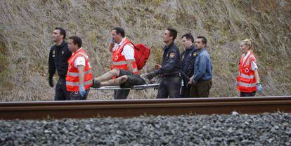 Personal de emergencias retiranun herido del lugar del accidente del tren.  
