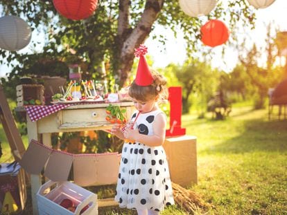 Little girl drinking juice on a birthday party outdoors,day