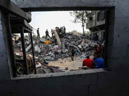 Palestinos buscan víctimas entre los escombros de una casa en Rafah (Gaza).