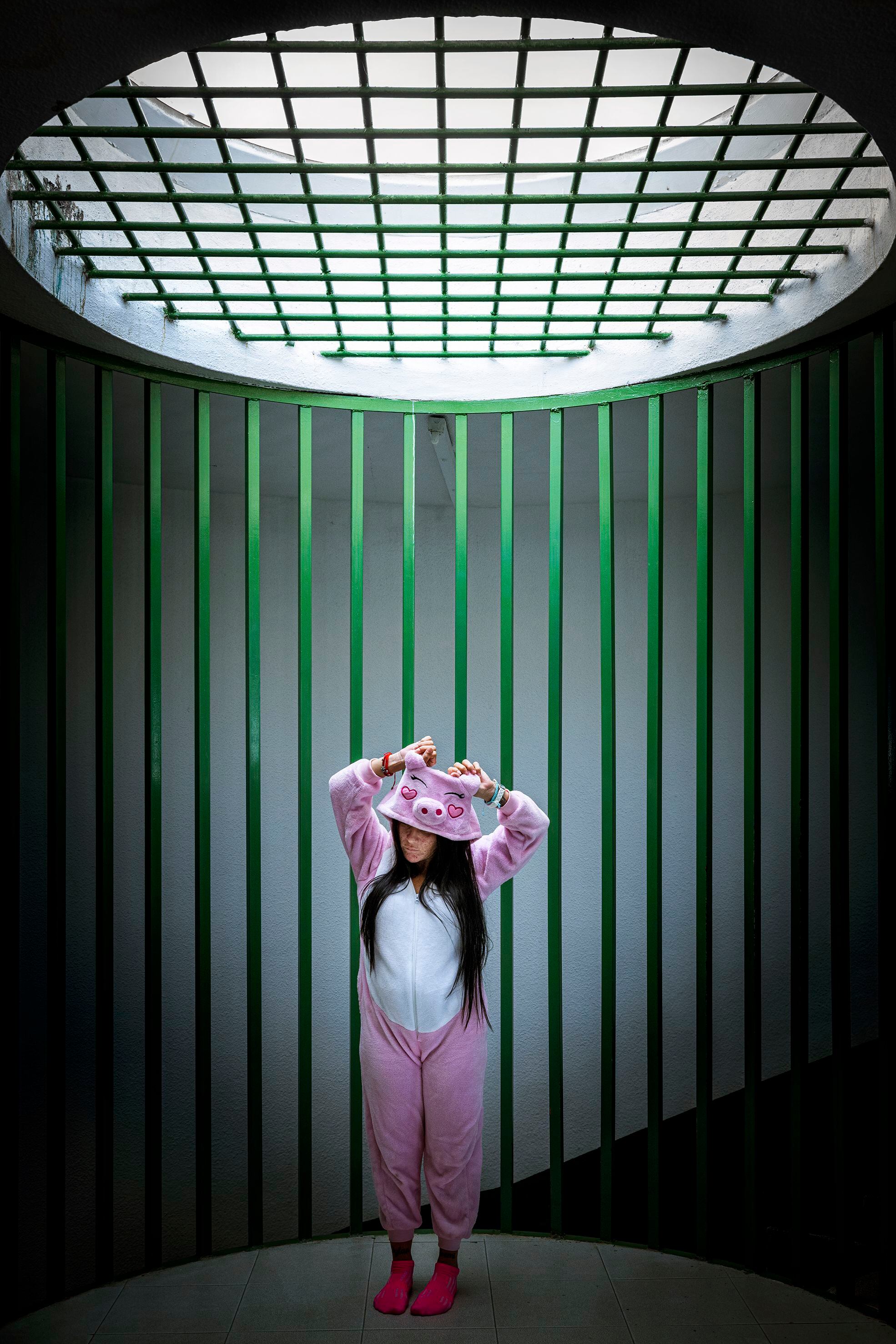 Una interna es retratada con un pijama de cerdita bajo el tragaluz próximo a la zona de acceso a celdas.