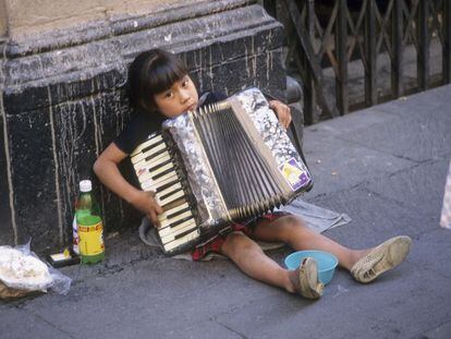 Una niña toca el acordeón en la calle, en Ciudad de México.