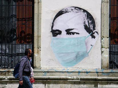 Una pareja camina este lunes junto a un mural alusivo al uso de las mascarillas, en una calle de Oaxaca, en julio de 2020.