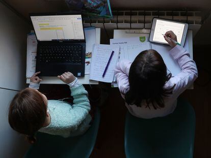 Dos niñas hacen los deberes durante las primeras semanas de confinamiento, en Madrid.