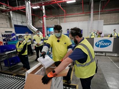 Un grupo de trabajadores llena una caja con dosis de la vacuna Pfizer-BioNTech en Kalamazoo, Michigan.