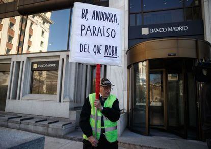Un hombre protesta en la puerta de la sede de Banco Madrid, en Madrid