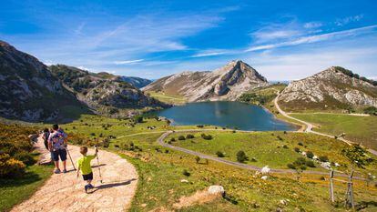 Visitantes ante el lago Enol, en Covadonga (Asturias), uno de los lugares más visitados del parque nacional de los Picos de Europa.
