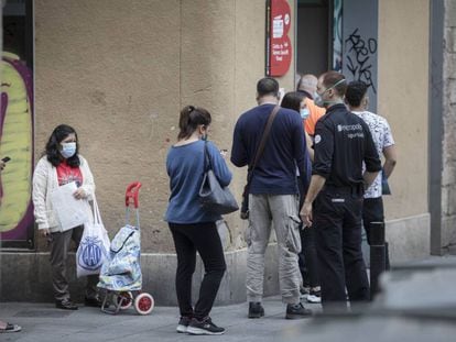 Cues davant d'una oficina al barri del Raval, durant el confinament.