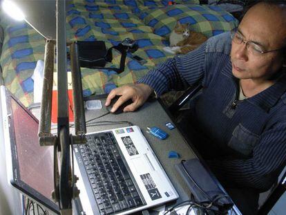 El <i>bloguero</i> chino Zhang Shihe, conocido como <i>Templo del tigre</i>, ante el ordenador, en su apartamento.