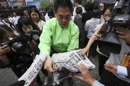 Un hombre reparte una edición especial de un periódico japonés que informa sobre la histórica reunión entre ambos mandatarios, en Tokio (Japón).
