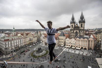 Un funambulista hace equilibrios sobre una cuerda floja en la Plaza de la Ciudad Vieja de Praga (República Checa).