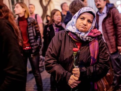 Una mujer turca sostiene un clavel durante un tributo a las víctimas del atentado de París en el exterior del consulado francés en Estambul.