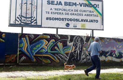 Un hombre camina junto a un cartel que caricaturiza a Lula encarcelado, ayer en Curitiba.