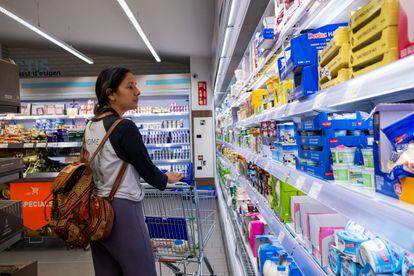 Una mujer observa el lineal de un supermercado.