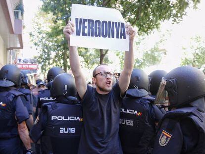 Un manifestant davant la seu de la CUP dimecres, quan la Policia Nacional va intentar requisar cartells electorals.