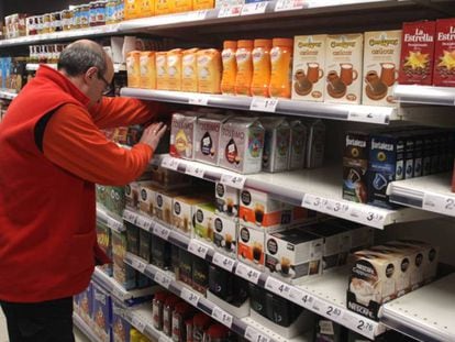 Un empleado coloca productos en un supermercado.