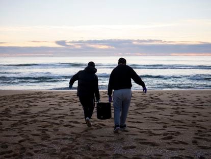 Una pareja de voluntarios durante la limpieza de los 'pellets' en la costa gallega.