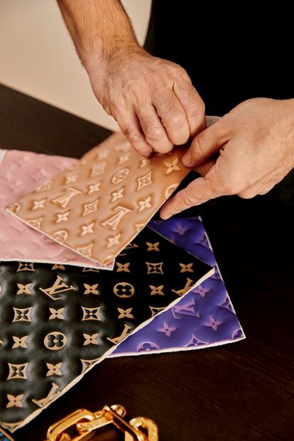 El diseñador manipula varios prototipos de cuero con el monograma de la enseña.