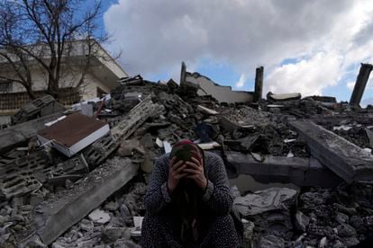 Una mujer sentada entre los escombros de un edificio en la ciudad turca de Nurdagi. 