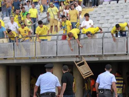 Aficionados del Las Palmas lanzan una silla desde la grada.