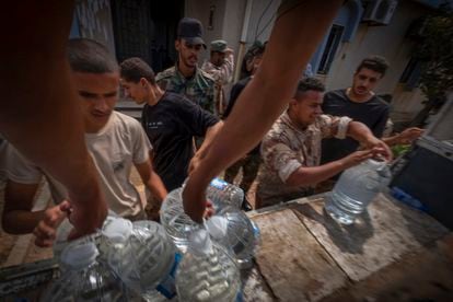 Un grupo de militares participa en el reparto de agua a la población de Derna (Libia). 