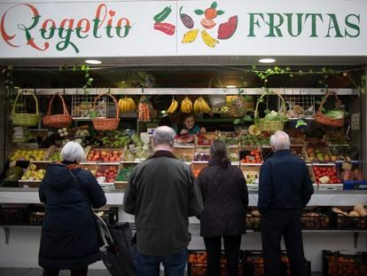 Varias personas esperan su turno en una frutería del mercado del Arenal en Sevilla, este viernes.