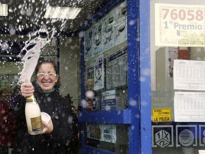 Una mujer descorcha una botella de champ&aacute;n en la administraci&oacute;n n&uacute;mero 12 de Alcal&aacute; de Henares, donde se han vendido 130 series del 76.058