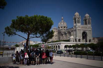 A group of tourists takes refuge in the shade of a tree, this Saturday in Marseille.