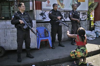 Una mujer que reside en la favela Alemão protesta frente a tres policías durante la redada.