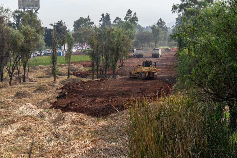 Una aplanadora cubre con piedra la parte del humedal donde se instalará el puente.