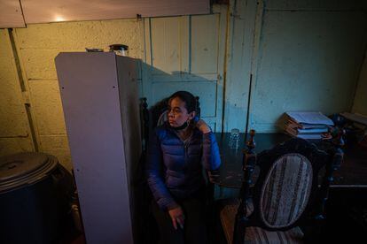 Adriana Ramírez en el comedor de su vivienda junto a sus botes dónde almacena agua.